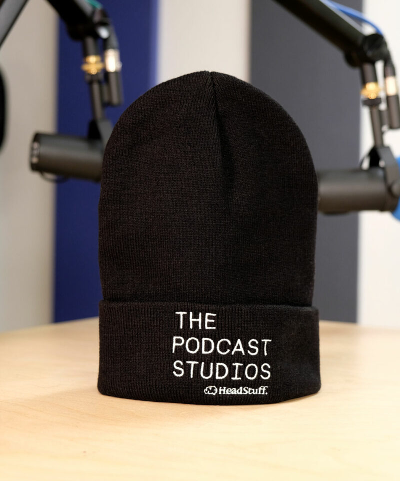 A black beanie hat emblazoned with the logo of The Podcast Studios Dublin